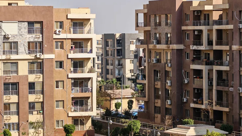 Des immeubles d'appartements résidentiels modernes avec des balcons et des climatiseurs, entourés d'espaces verts.