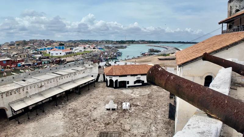 Vue panoramique de Cape Coast depuis le fort : toits de la ville, port et baie