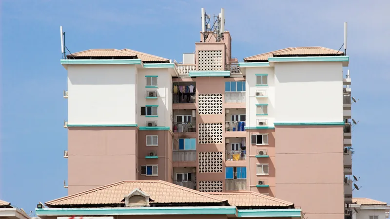 Immeuble d'appartements résidentiels de plusieurs étages avec des balcons et une antenne sur le toit.