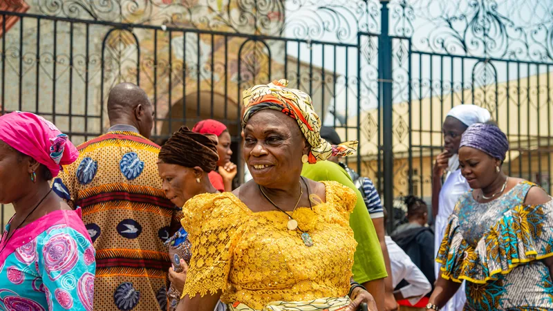 Groupe de personnes en tenues traditionnelles colorées devant une grille ornée