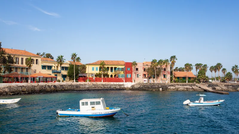 Maisons colorées au bord de l'eau avec des bateaux de pêche, toits en tuiles et palmiers