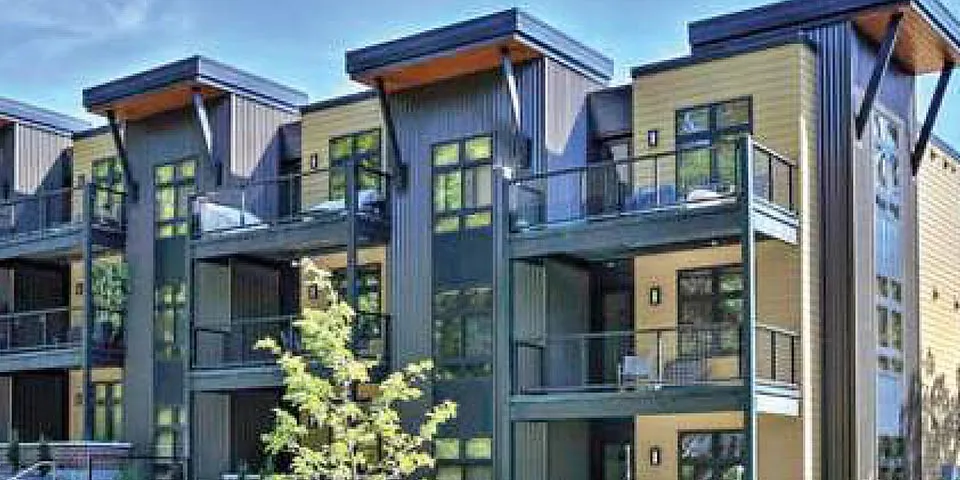 Modern multi-story apartment building with balconies and large windows.
