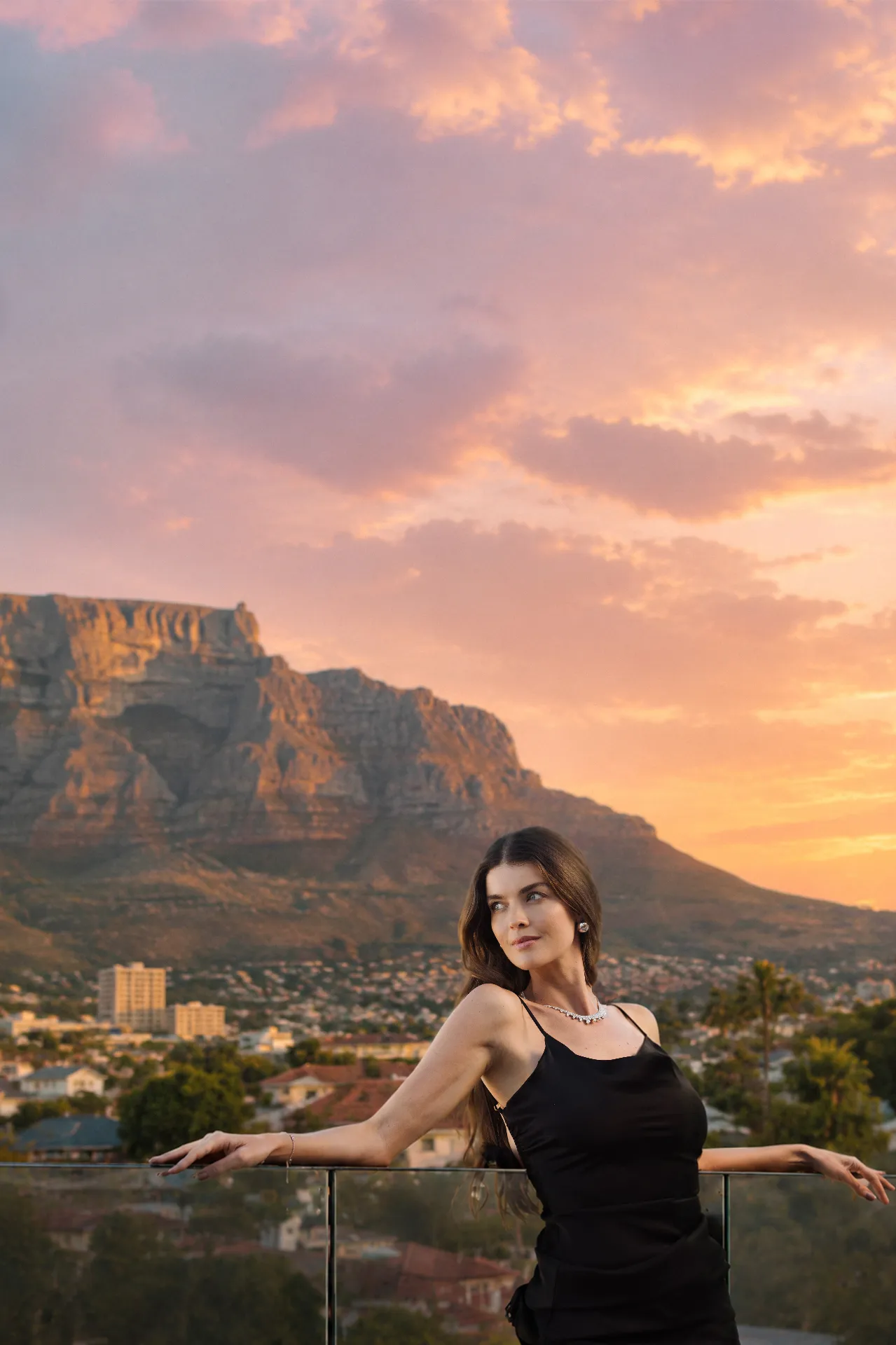 Woman on a balcony at sunset with Table Mountain behind