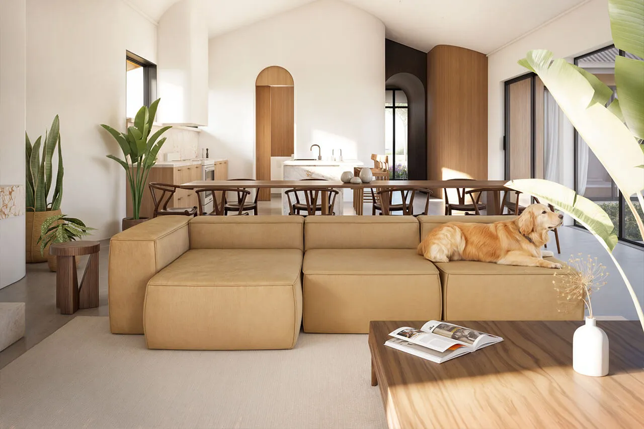 Bright and inviting living room featuring a beige sofa, large windows, and lush indoor plants.